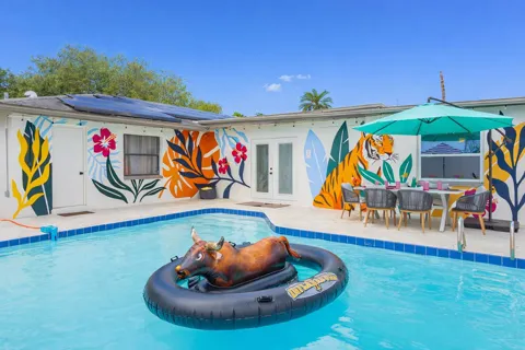 Pool with tropical mural and patio dining