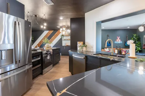 Kitchen with dark island and stainless appliances